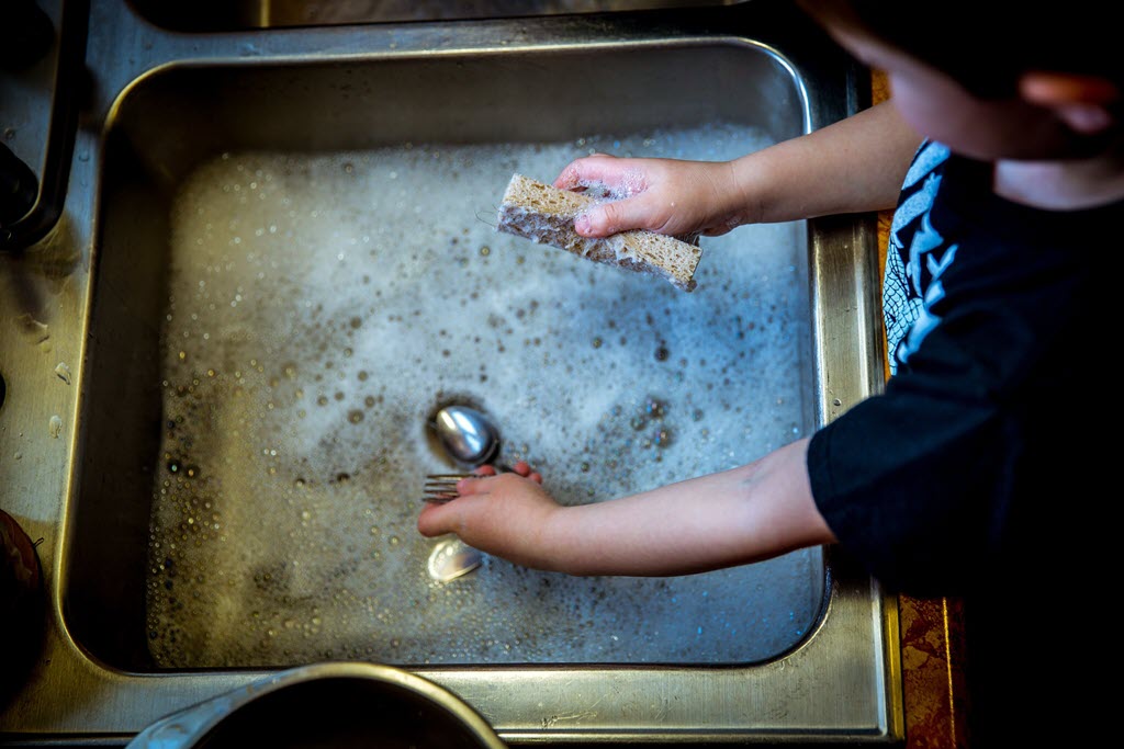 boy washing dishes on the sink